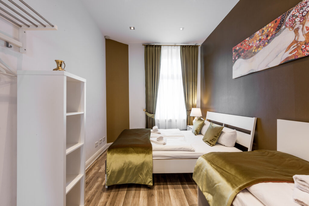 Helles Schlafzimmer mit Einzelbett, Nachttisch und Holzboden.