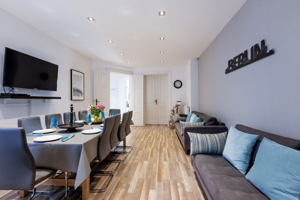 Längssicht auf den Wohn- und Essbereich mit Holzboden und blauer Sitzbank